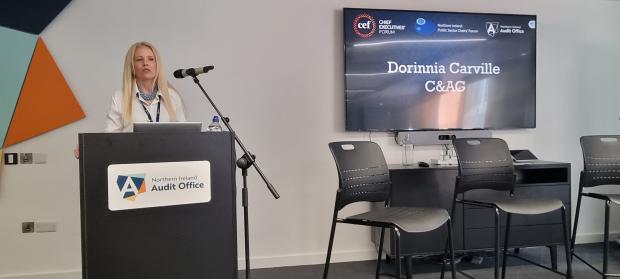 Auditor General Dorinnia Carville addresses delegates from behind a lectern.
