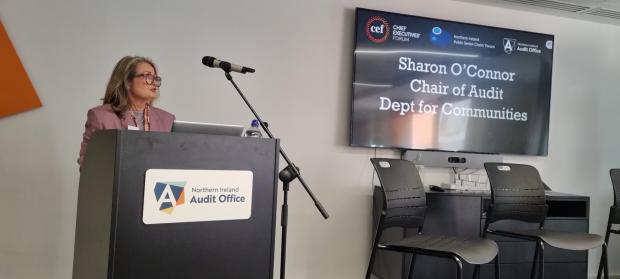 Sharon O'Connor addresses attendees from behind a lectern.